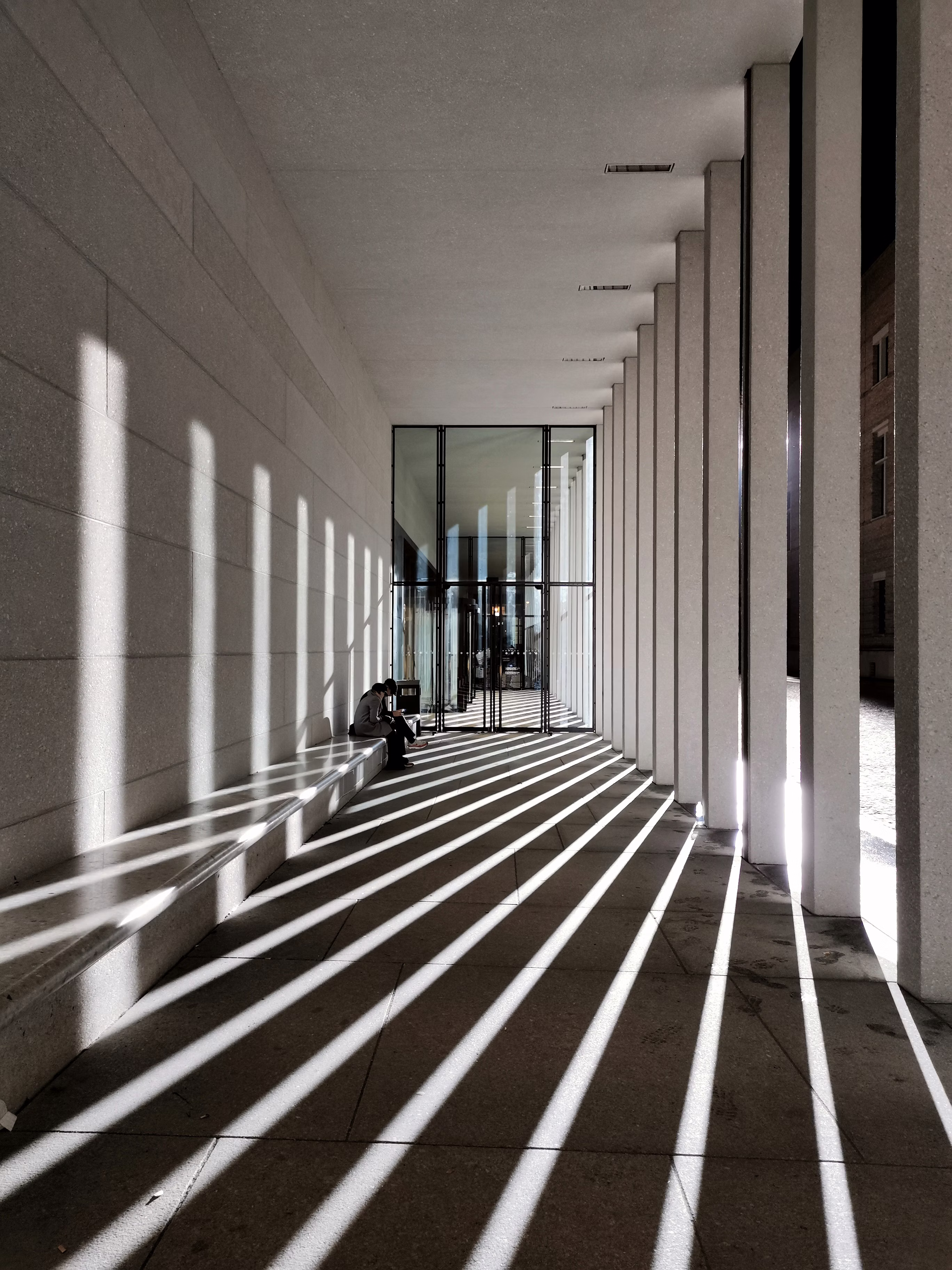 Sunlight across a quiet civic walkway.